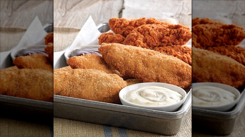 The regular and spicy chicken tenders from Culver's on a tray with sauce