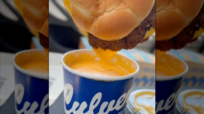 Food content maker HellthyJunkFood dipping a Culver's ButterBurger into its cheese sauce