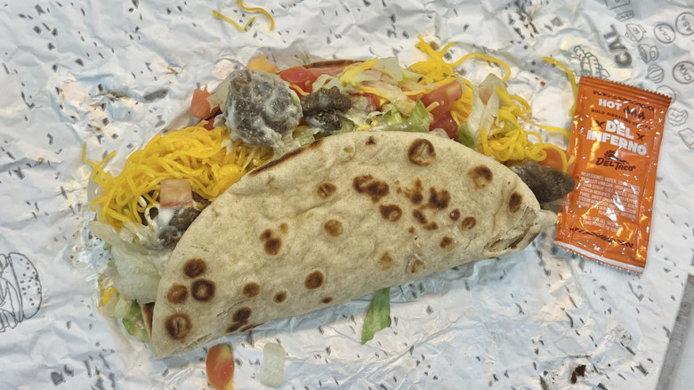 Del Taco Carne Asada Steak Big Fat Taco with sauce on wrapper.