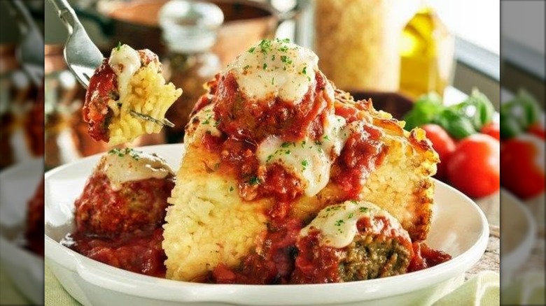 Olive Garden spaghetti pie with meatballs on white plate