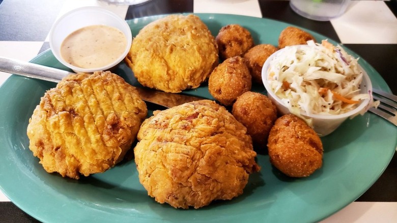 Crab cakes, hush puppies, and coleslaw on teal plate