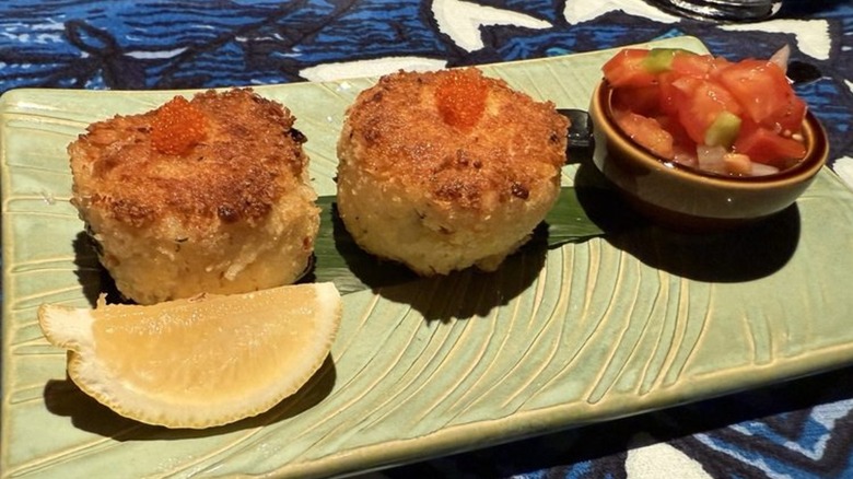 Two crab cake son plate with lemon and salsa