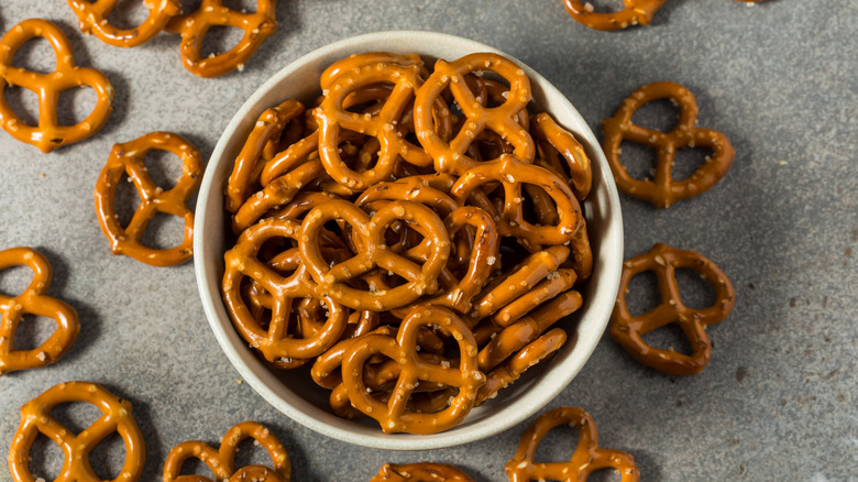 A bowl of pretzel twists on a gray background