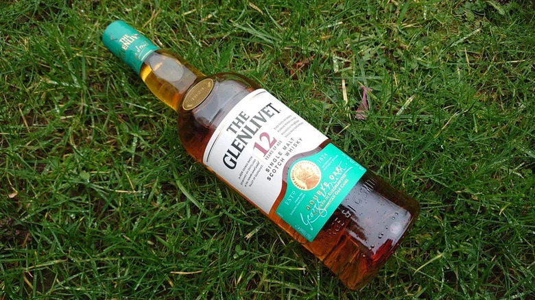 A top-down shot of a bottle of The Glenlivet 12-year laid on grass