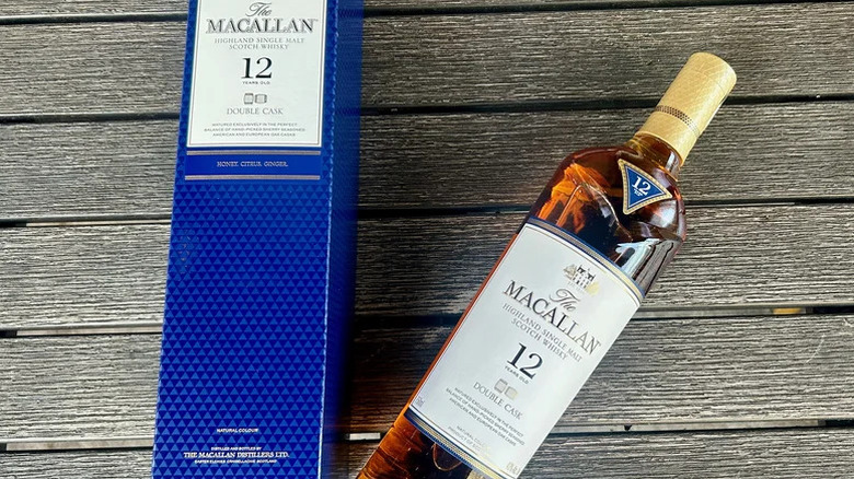 A bottle of The Macallan 12-year Double Cask placed on a wooden surface next to its box