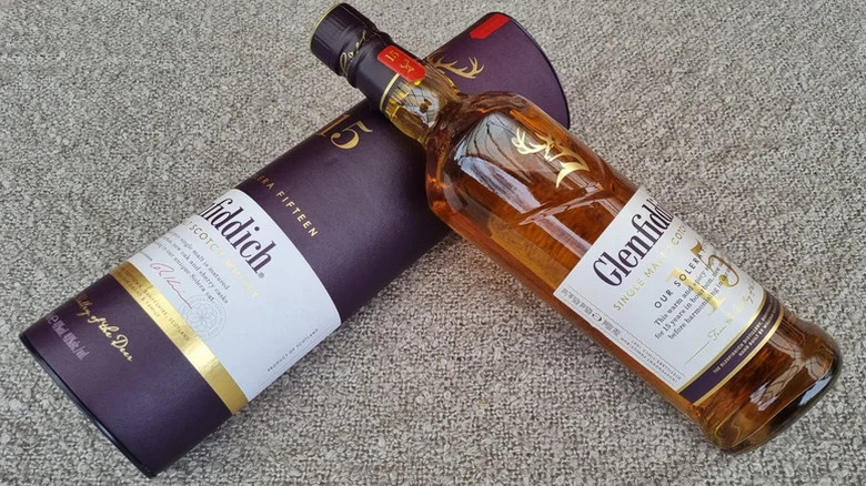 A top down shot of a bottle of Glenfiddich 15-year laid on its packaging