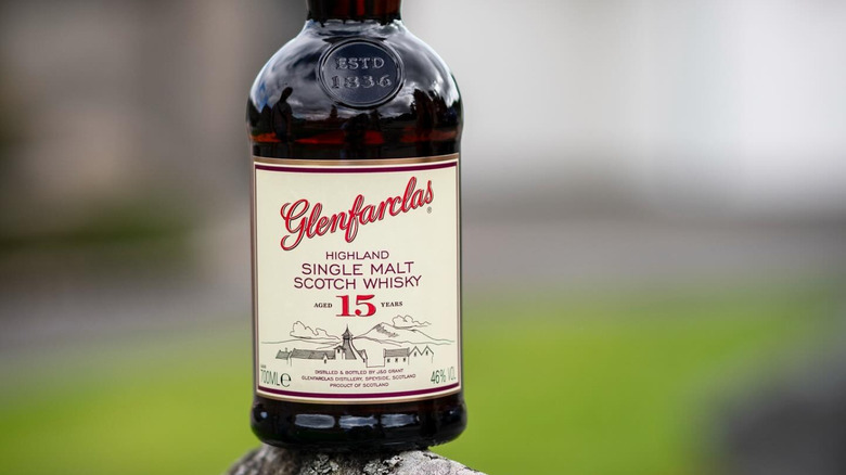 A bottle of Glenfarclas 15-year delicately posed on top of a rocky surface