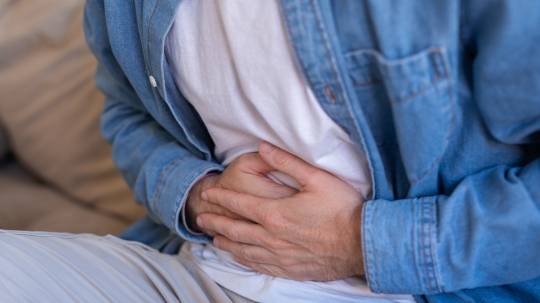 close up of person clutching stomach