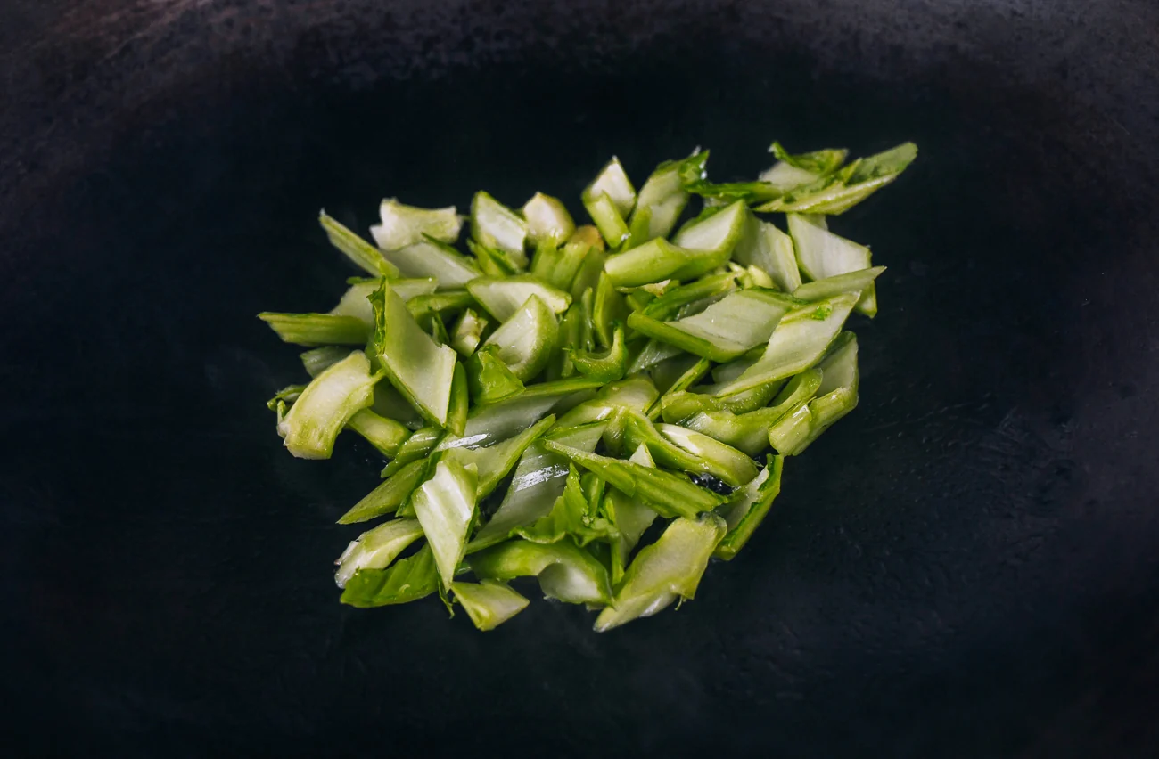 stir-frying mustard green stems in wok