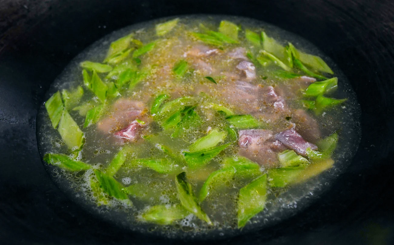 pork slices added to mustard green soup