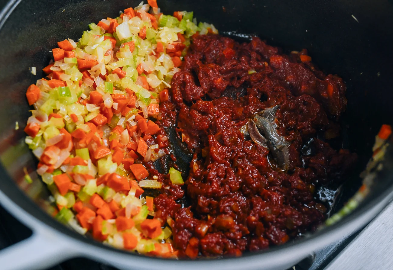 anchovies added to pot with vegetables and tomato paste