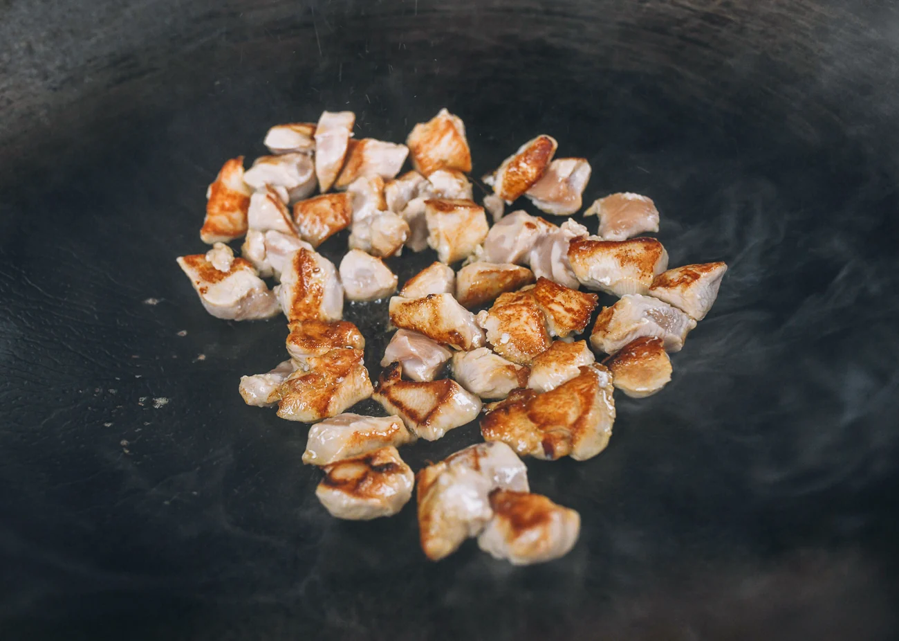 seared cubed chicken in wok