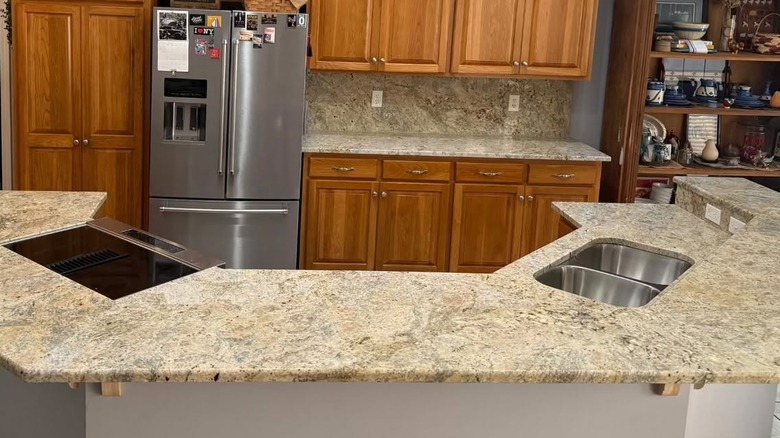 A kitchen with Colonial Cream granite countertops paired with warm, honey oak cabinetry