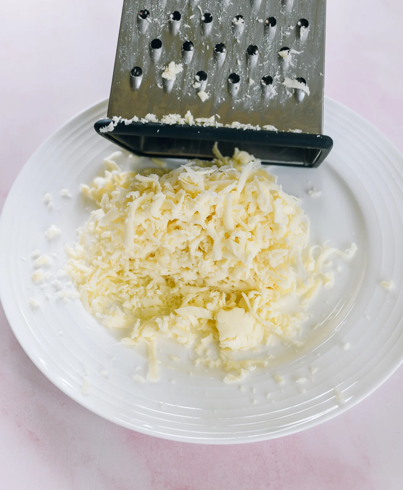 grating mozzarella cheese on box grater