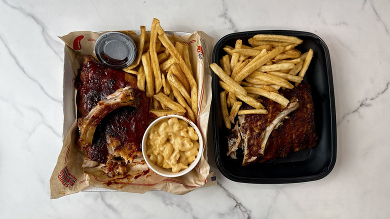 Chili's and Applebee's baby back ribs with fries in takeout containers and one rib on top