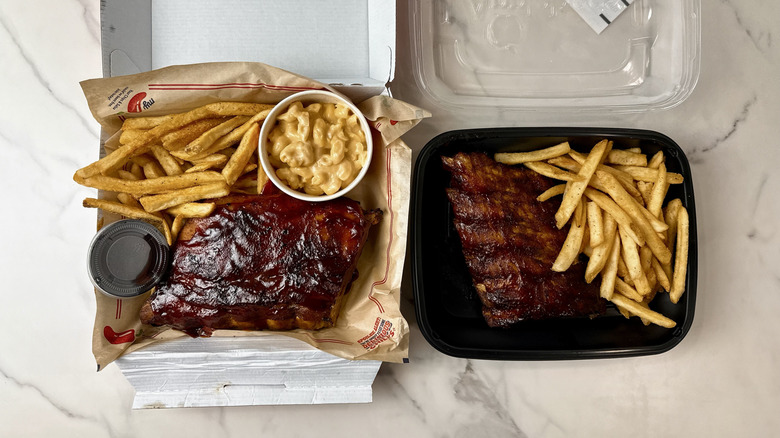 Chili's and Applebee's baby back ribs with fries in takeout containers on a marble background