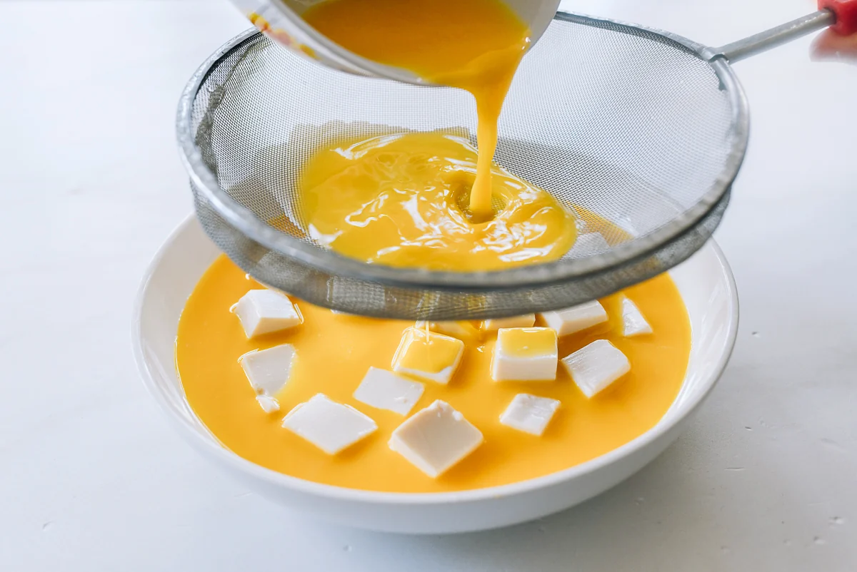 pouring steamed egg mixture over tofu