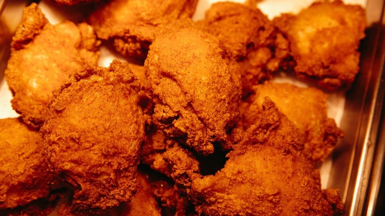 Close-up of golden fried chicken on sheet tray
