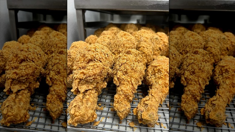 Close-up of fried chicken legs on metal rack